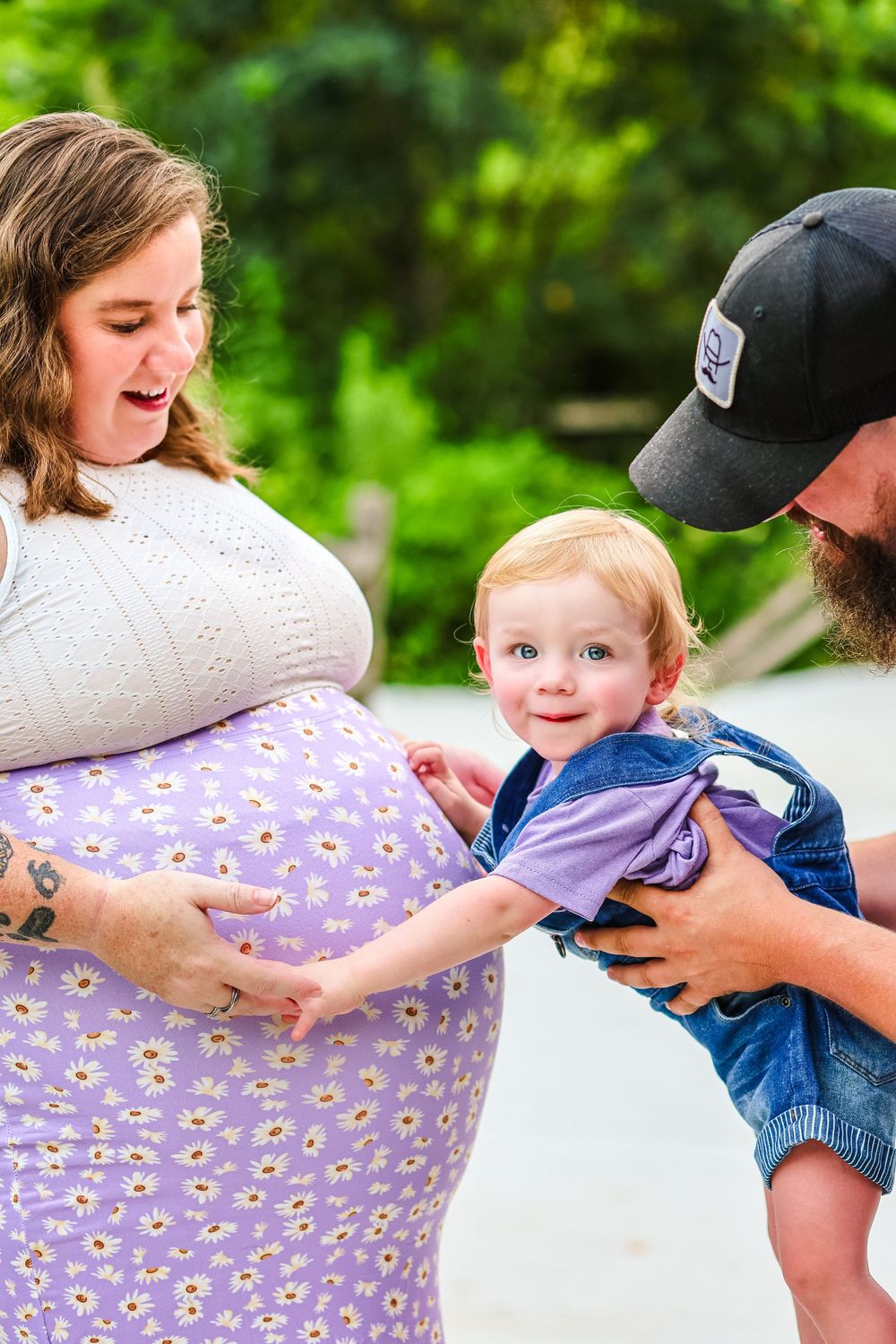 A maternity picture of a dad holding his son to hug his mothers pregnant belly. Maternity/ family photoshoot