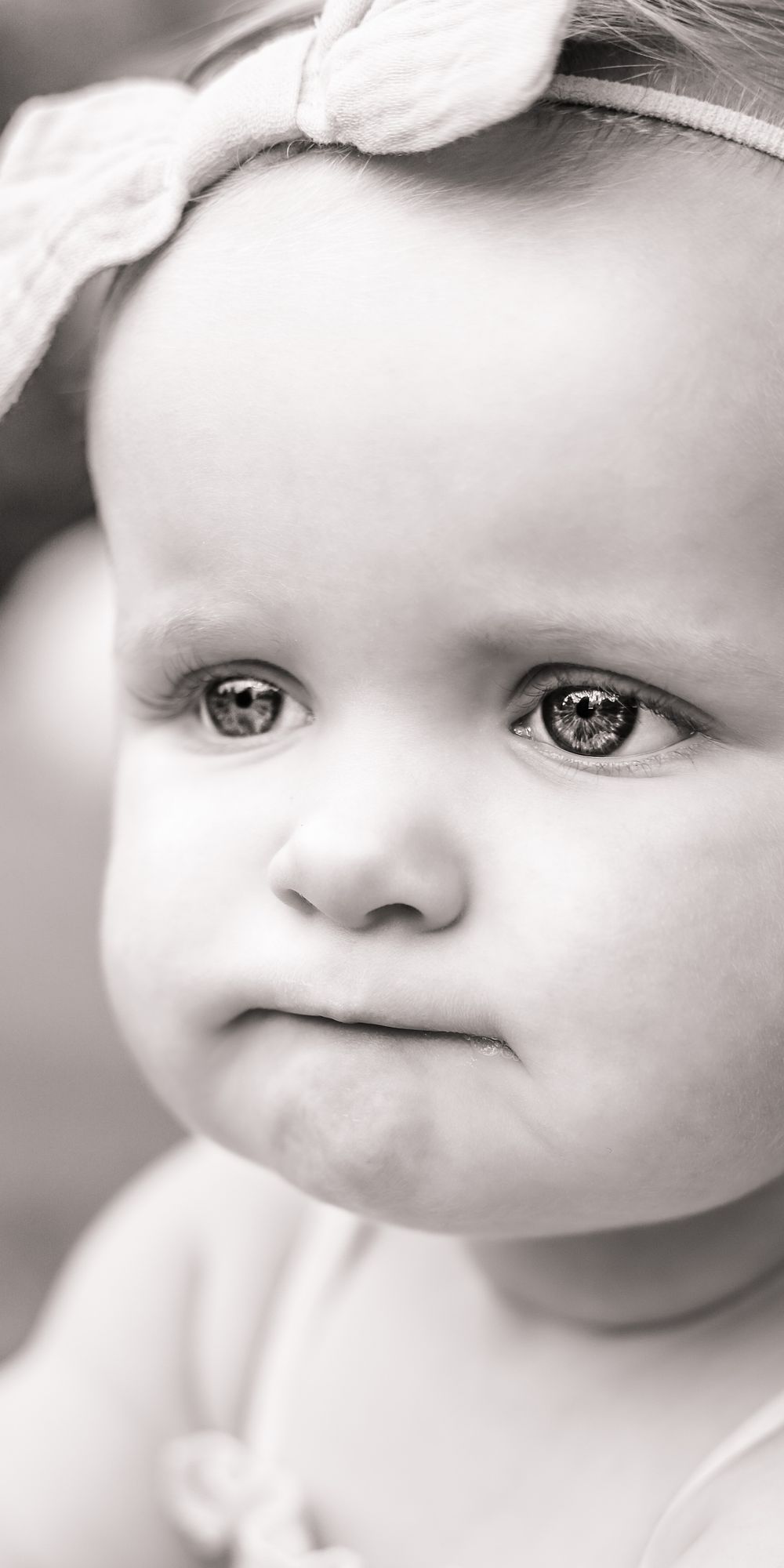 A close-up black and white image of a baby girl/ editorial style/ lifestyle image.