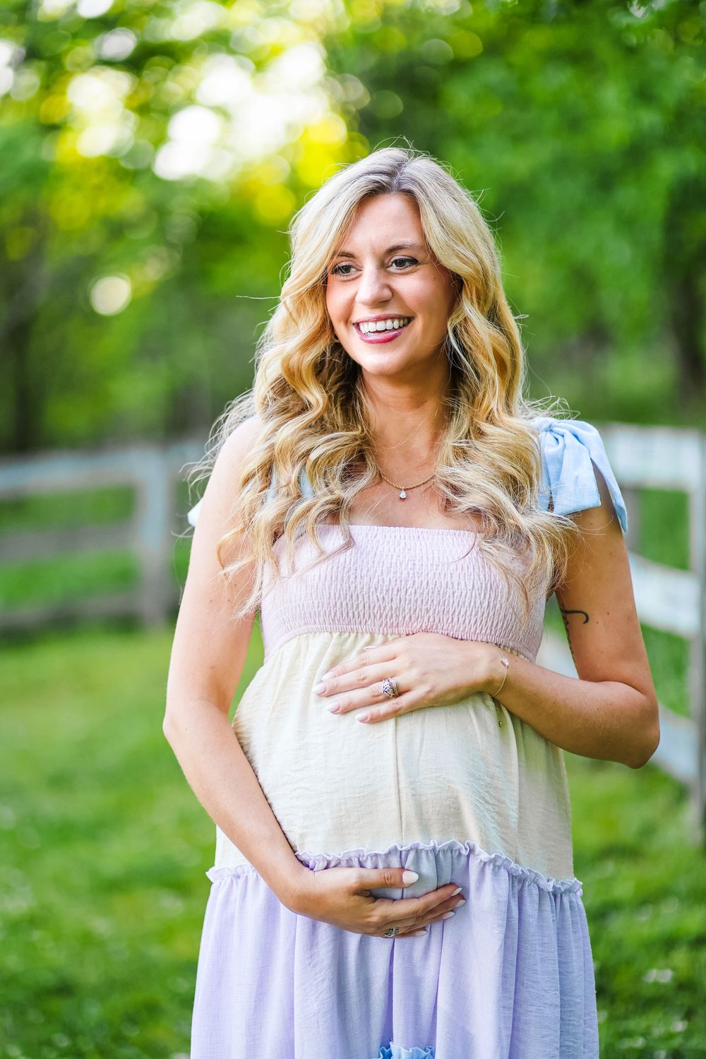 A maternity lifestyle image of a mother looking off to the side and smiling.