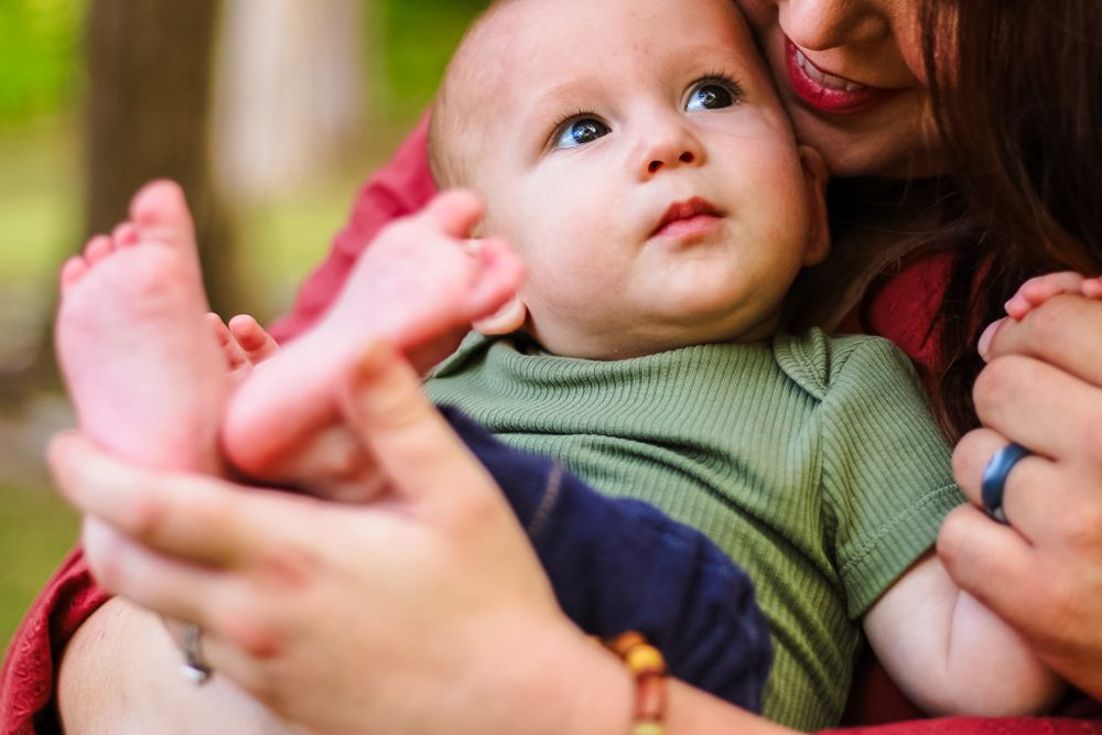 A candid lifestyle image of a mother holding her baby and feet.