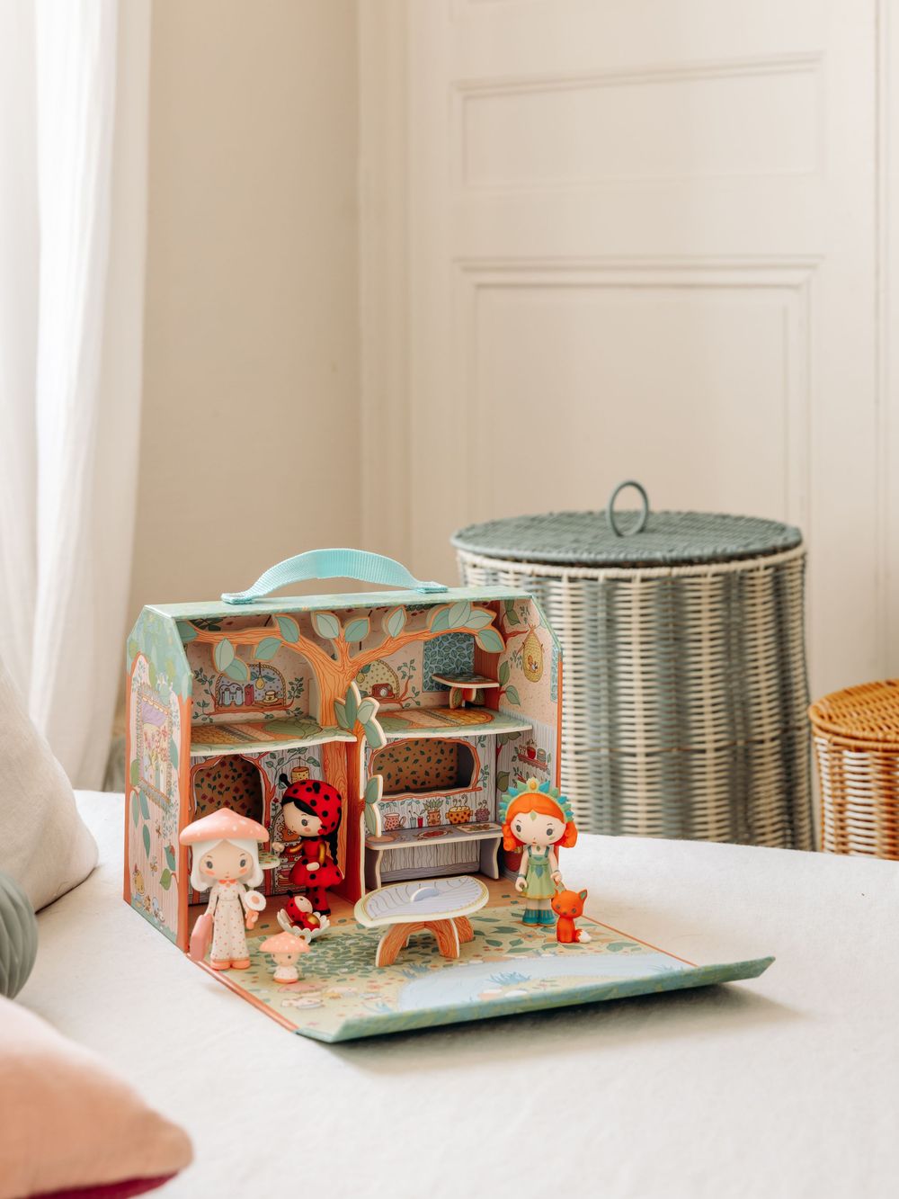 A charming portable dollhouse playset with illustrated fairy tale characters and woodland decor, open on a white surface.