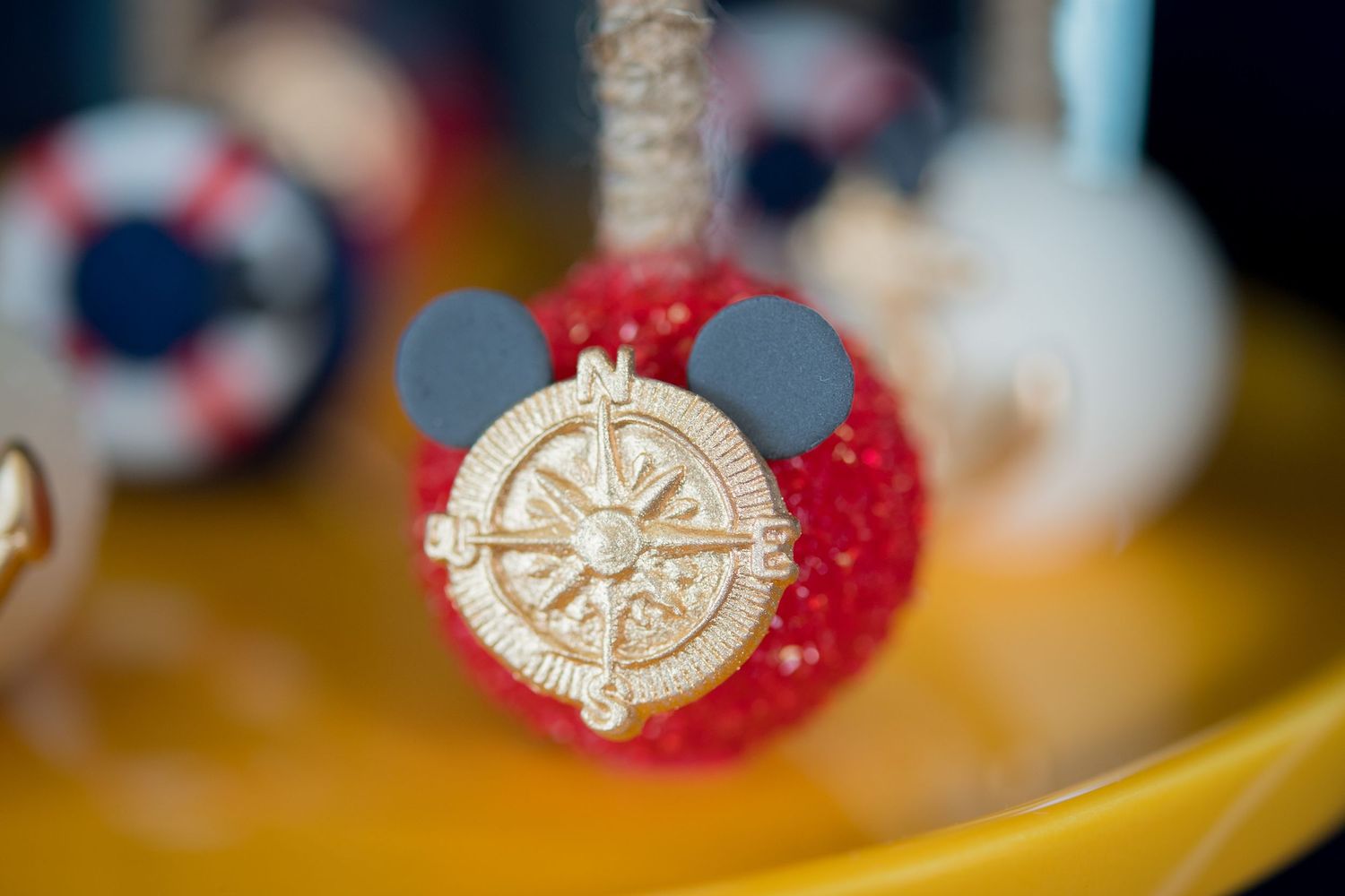 Red and white nautical-themed Mickey Mouse cake pop with a decorative compass design.