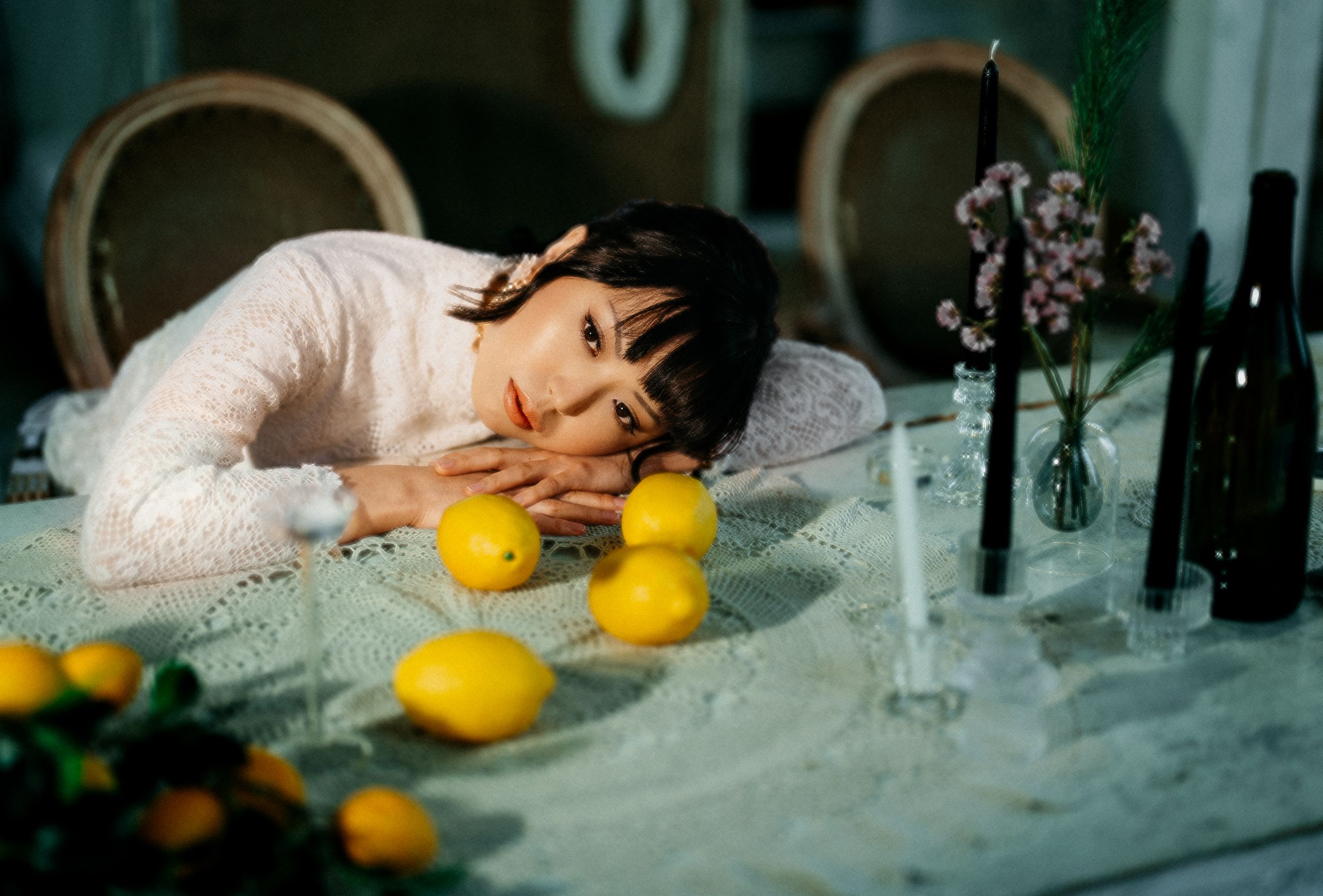 a bride in a retro dress resting her head on a table with lemons