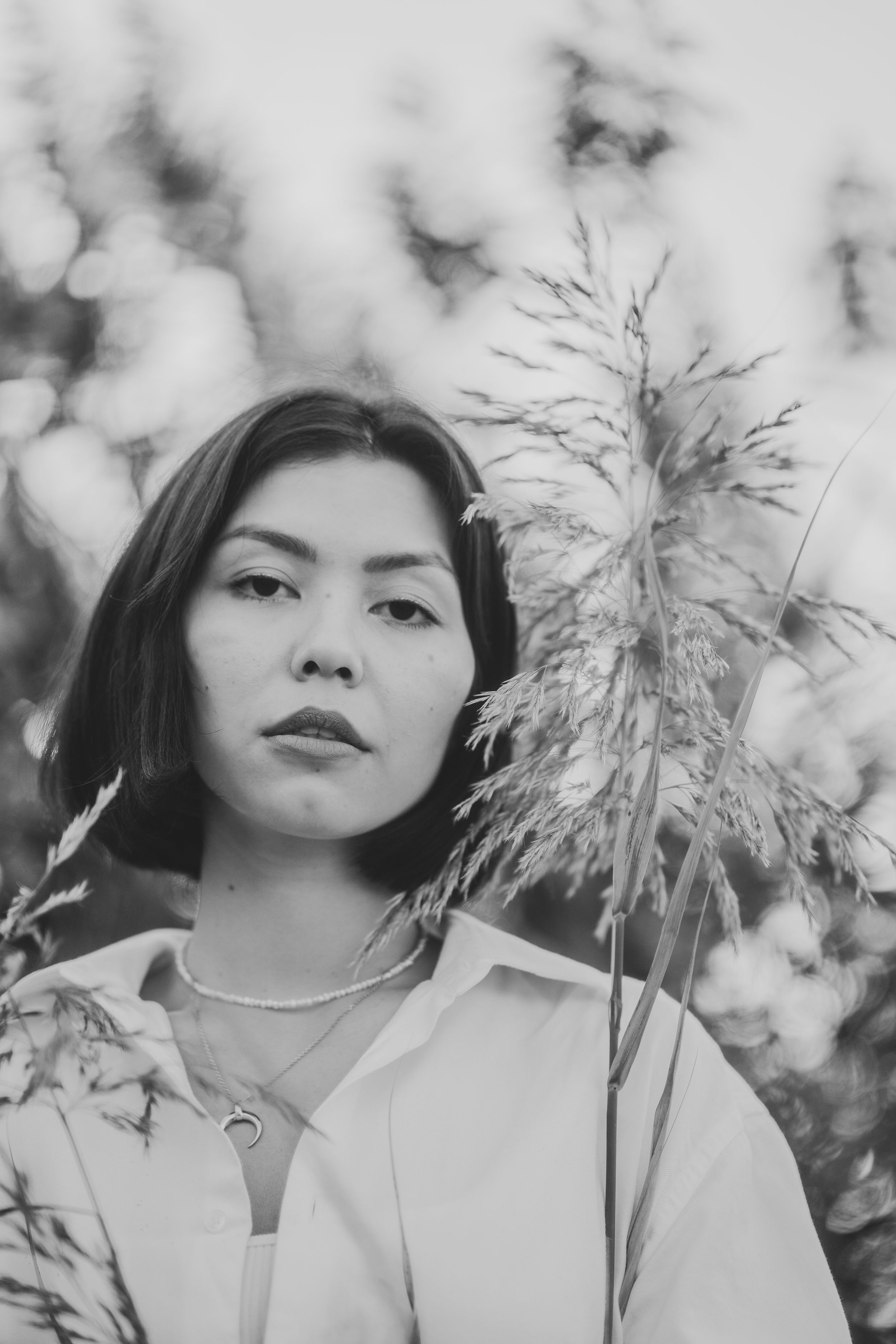 Black and white portrait of a girl in a white shirt in a field