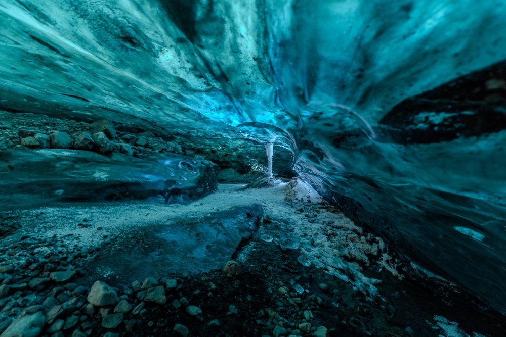 Backlit turquoise ice glows in this image of the inside of an ice cave in Iceland.