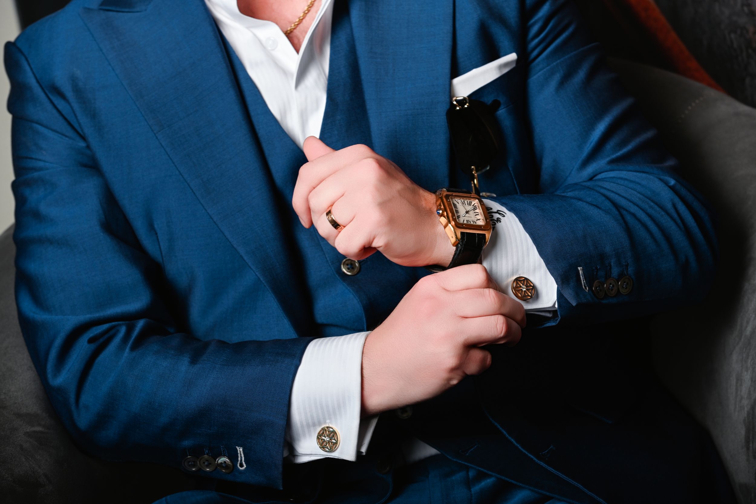 Luxury portrait of  Ace in a tailored blue suit adjusting his gold watch during an editorial fashion photoshoot in Las Vegas