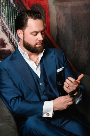 Luxury portrait of  Ace in a tailored blue suit adjusting his gold watch during an editorial fashion photoshoot in Las Vegas