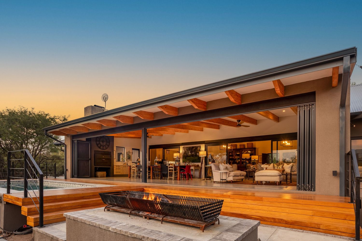Luxury villa exterior at sunset with pool and patio area