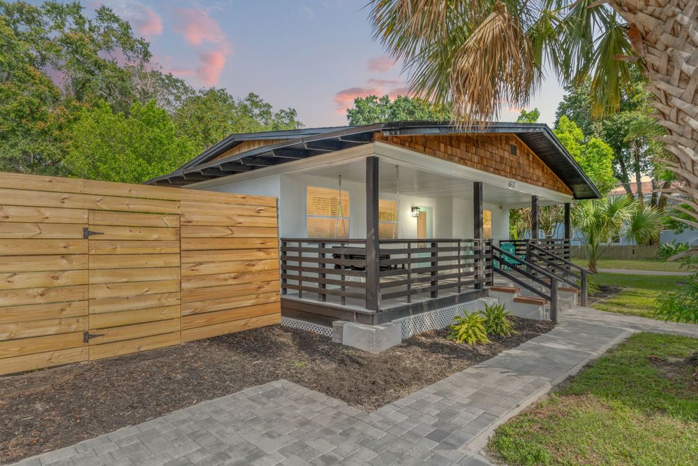 Modern home exterior with wooden fence details and landscaped yard.