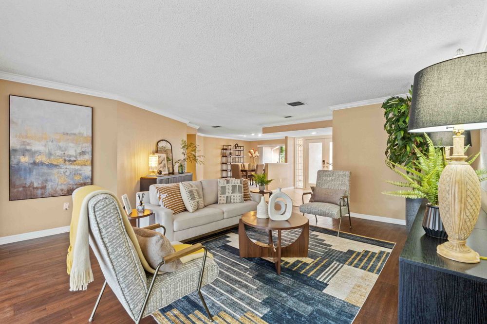 Elegant living room with beige walls, ceiling fan, and stylish furniture arrangement.