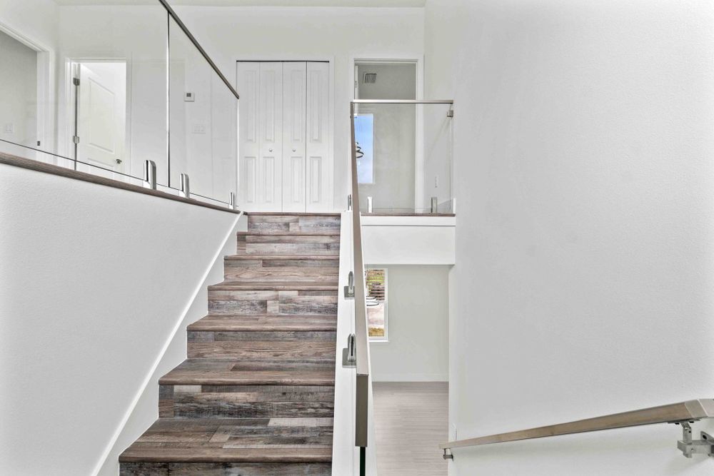 Contemporary kitchen featuring white cabinets and light wood flooring in an open layout design.