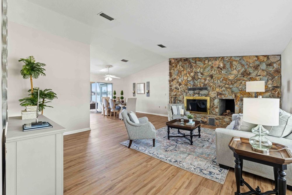 Spacious living area with stone accent wall, modern furnishings, and natural lighting.