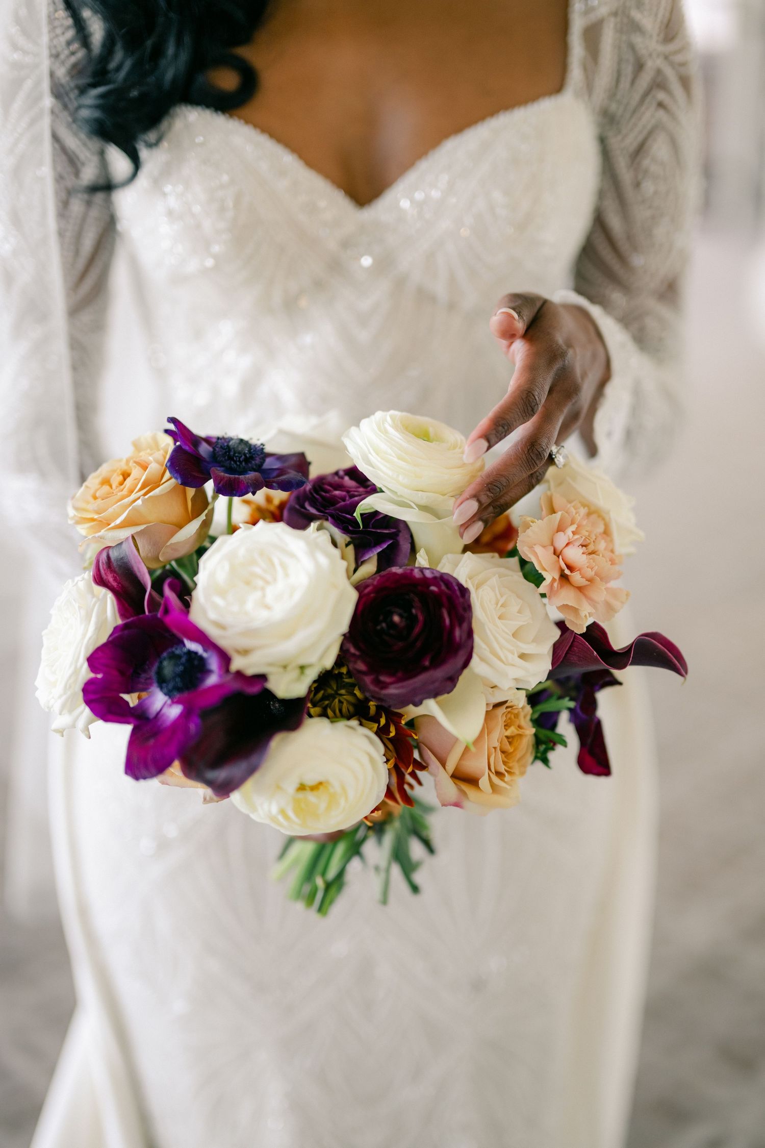 Bride in beaded white gown holding a lush bouquet of purple, cream, and peach roses and anemones. - University Club of Chicago Wedding