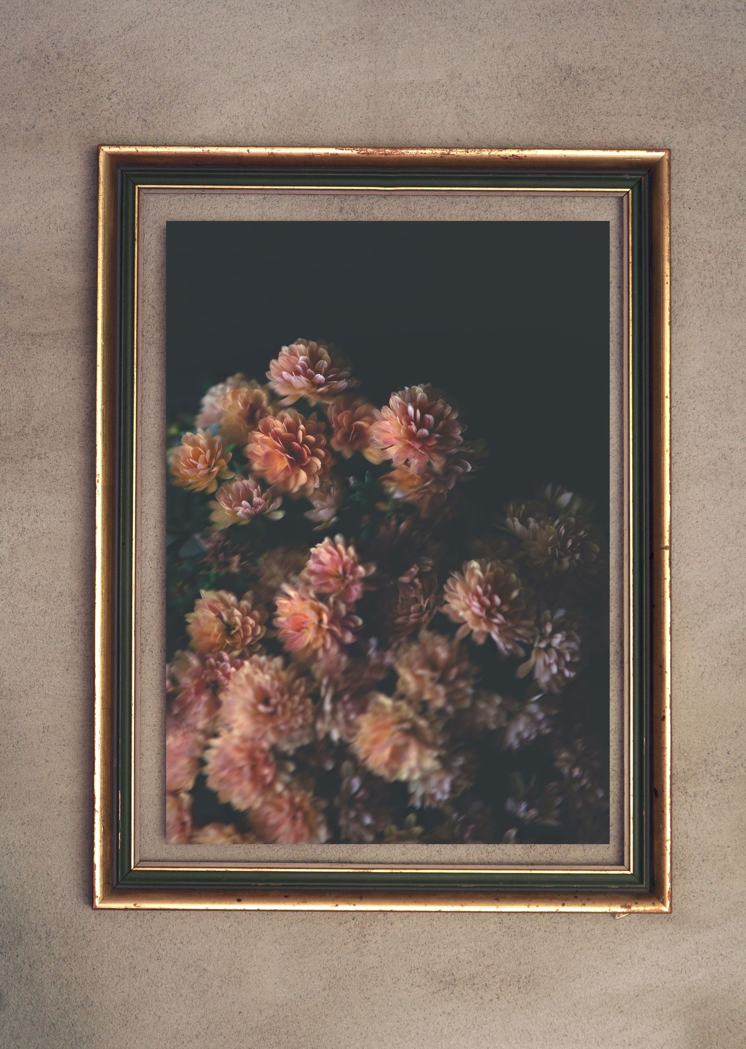 En tavla som hänger på en betongvägg. Tavlan består av ett fotografi av flera blommor som är i olika nyanser av rosa.