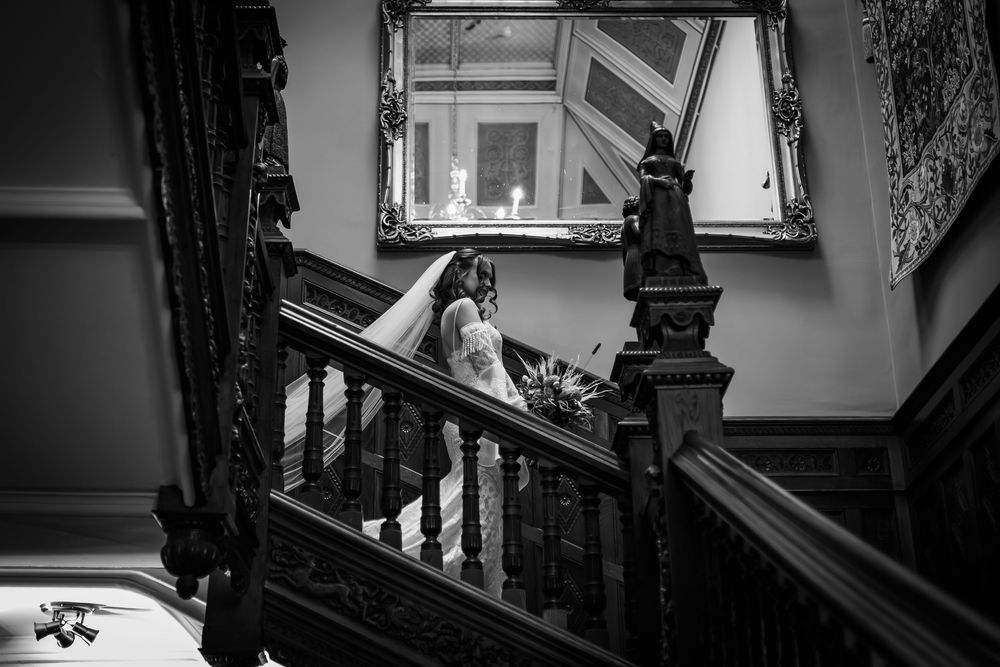 Black and white architectural photograph showing dramatic angles of a spiral staircase in an urban building.