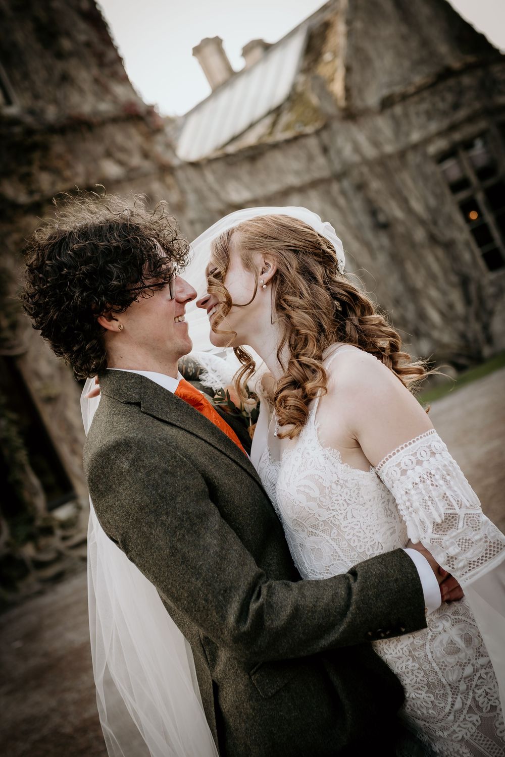 A romantic sequence of wedding photos showing a couple sharing intimate kisses against a stone wall backdrop.