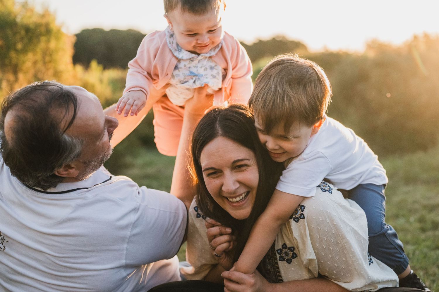 Familia riéndose, con bebé de un año y niño de 3 años durante una sesión de fotos familiar en tandil