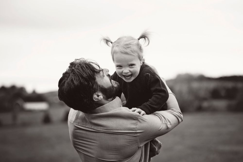 Joyful moment captured in black and white against outdoor landscape.