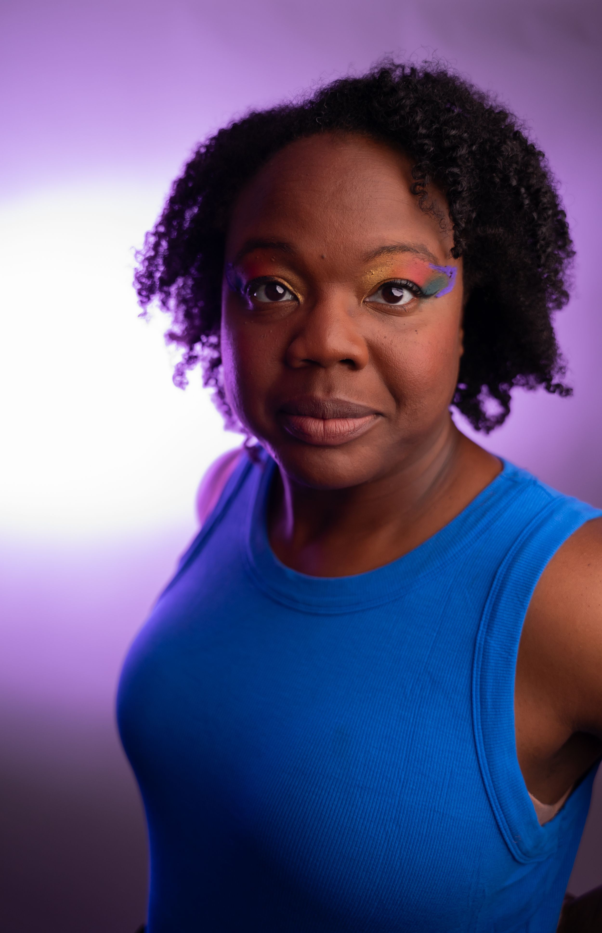 Studio portraits featuring a bright blue top against a purple background.