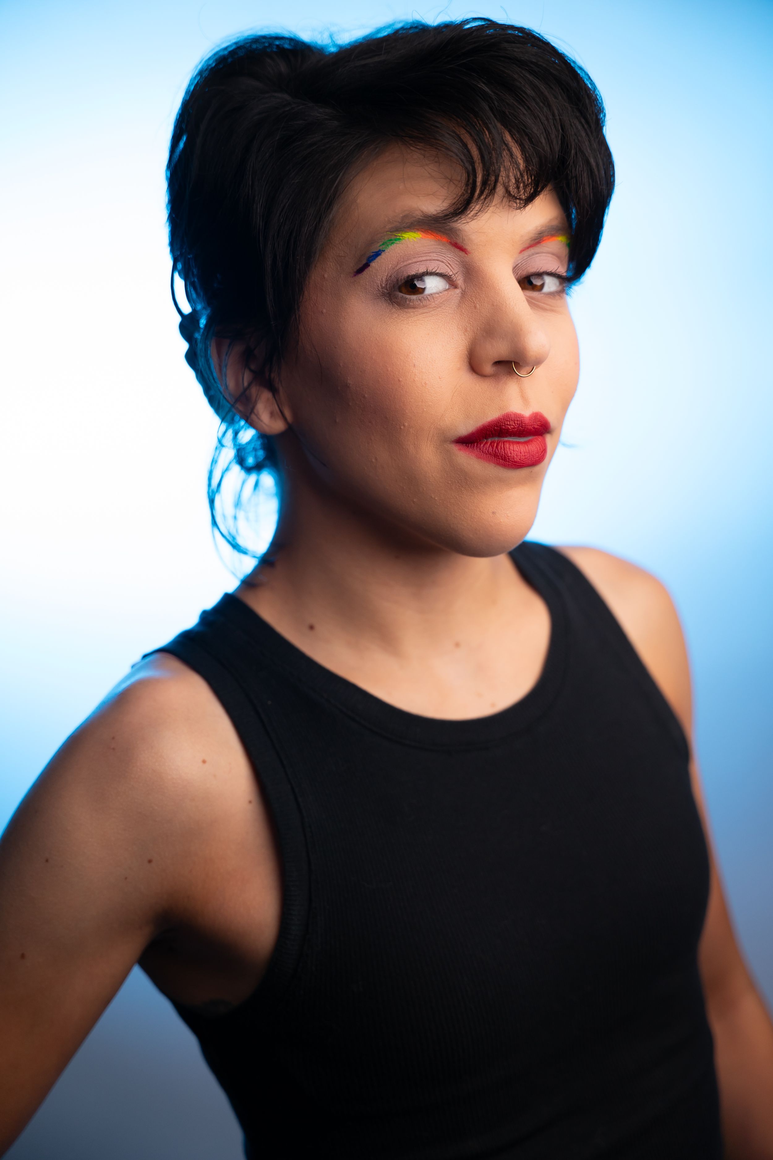 Portrait series in a black sleeveless top against a blue background.