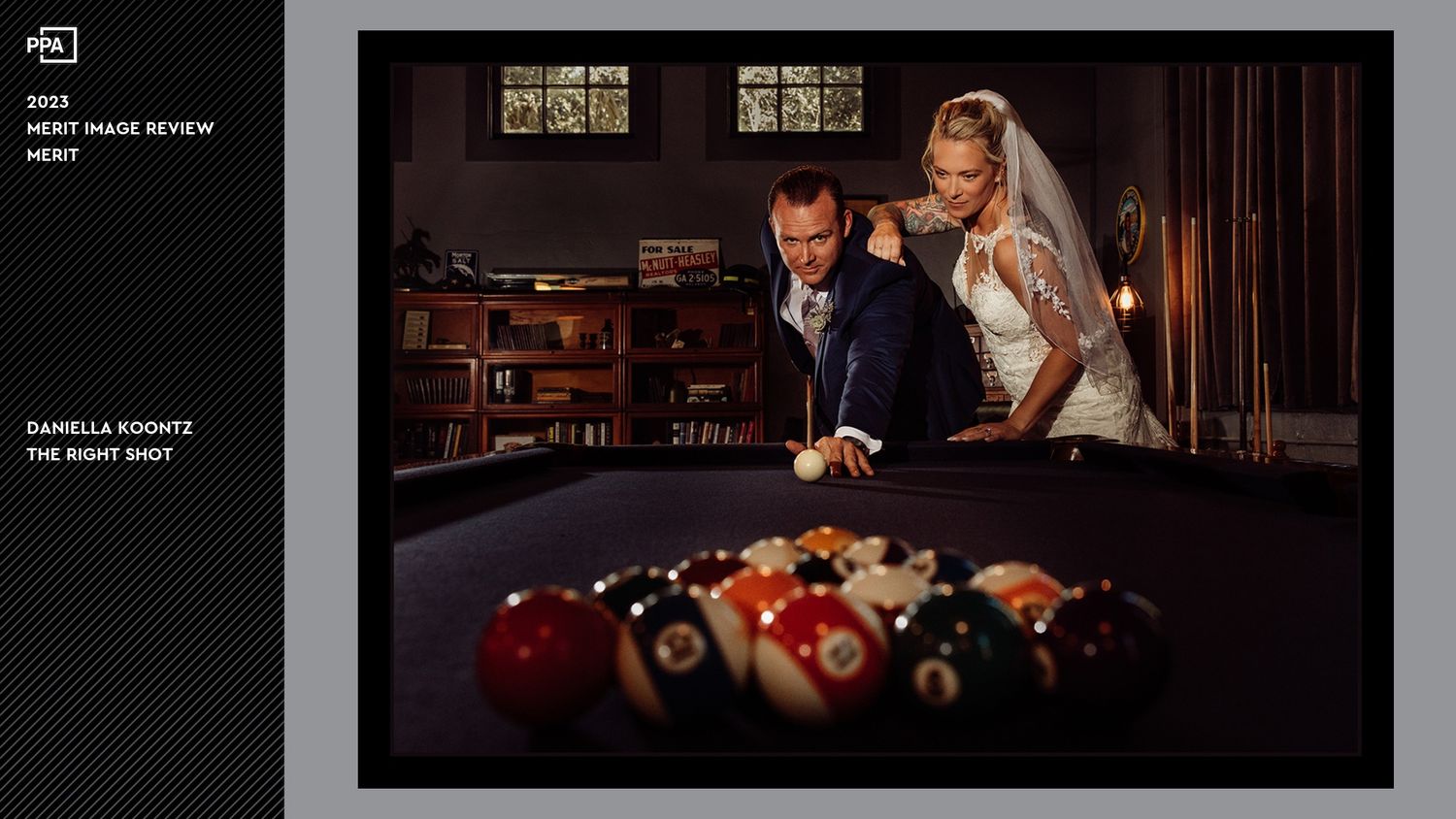 Couple posing at a pool table in formal attire with billiard balls in the foreground.