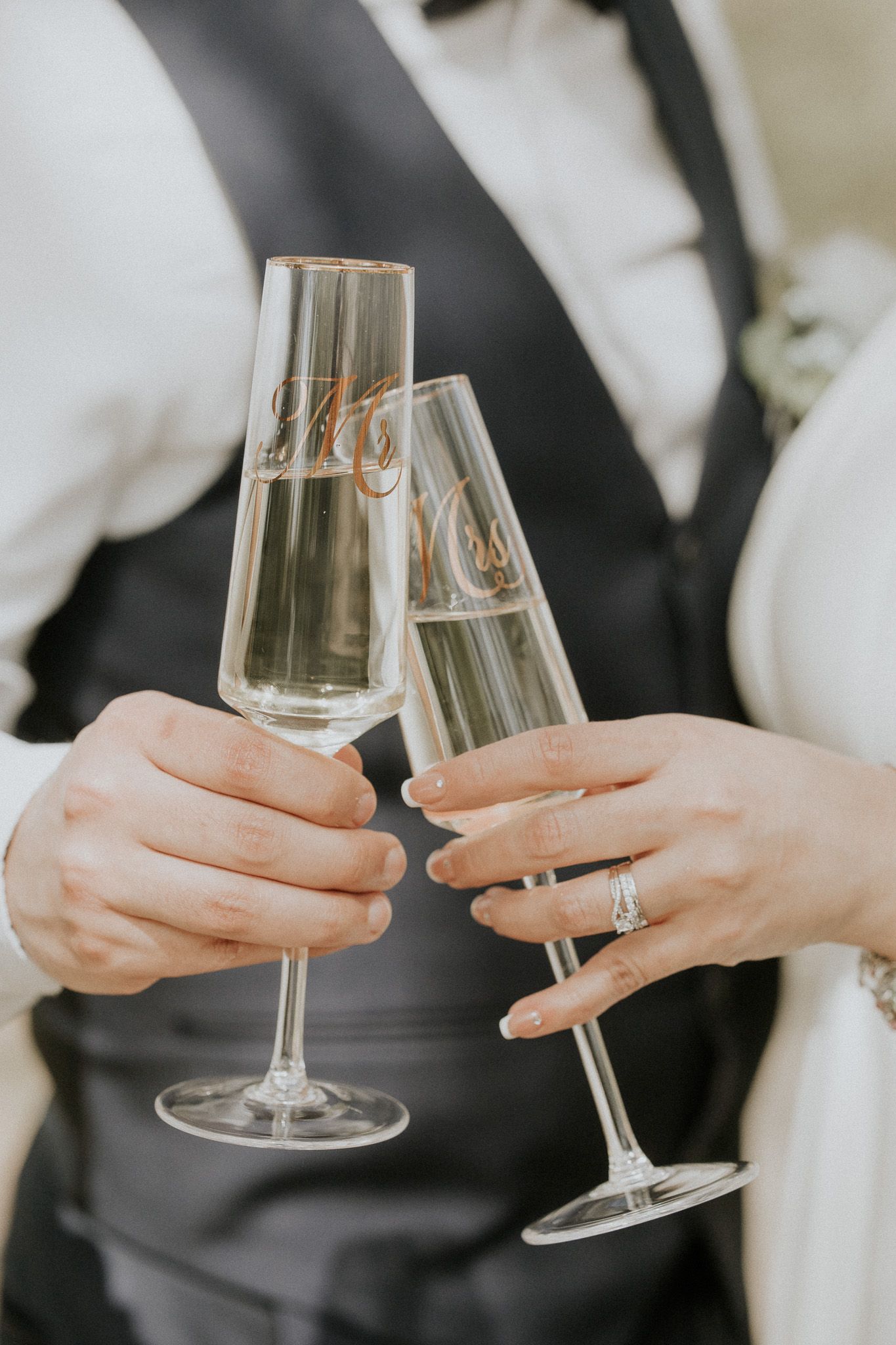 Two champagne flutes clinking in celebratory toast with decorative text.