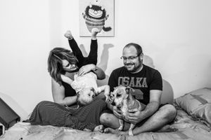 Family bonding moments with their dog on a couch in monochrome.
