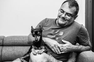 Series of intimate black and white photos showing a dog receiving affection on a couch.