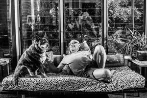 Dog lounging on a floral patterned cushion in a series of connected black and white photos.