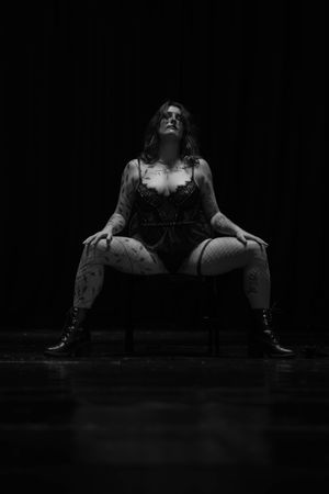 Figure in dark shadowy setting shown in dramatic black and white contrast.