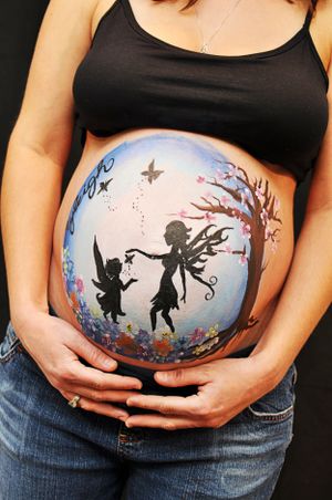Fairy silhouette belly art painting with magical woodland scene.