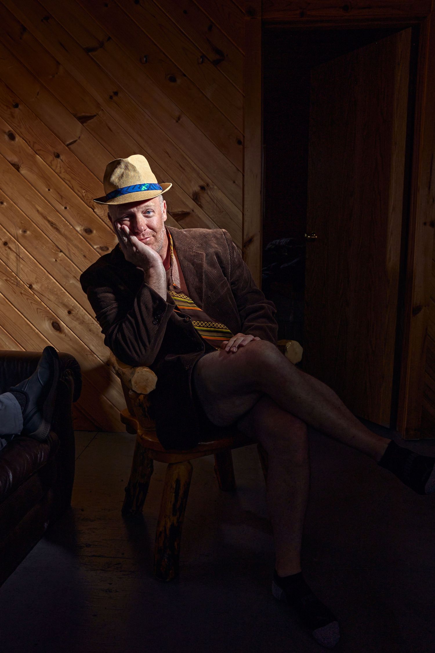Dimly lit cabin interior with person relaxing in comfortable chair.