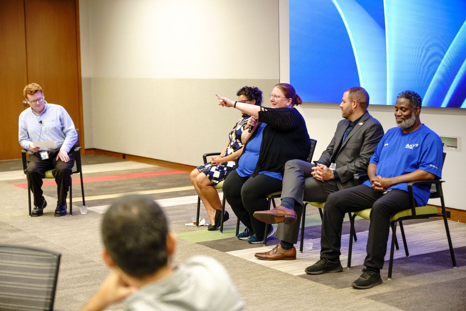 Conference room setup with blue lighting and attendees seated in rows.