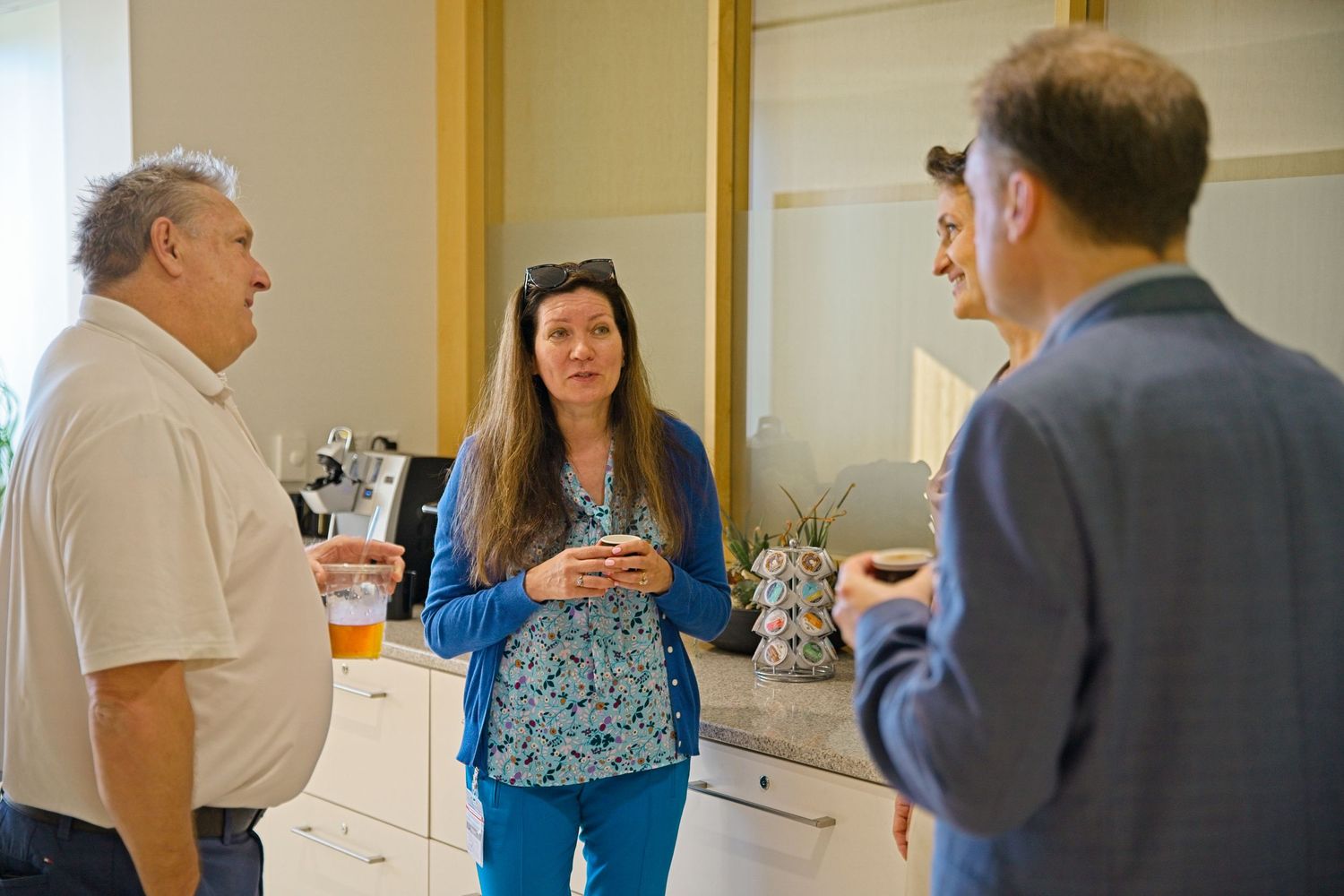 Networking event with professionals mingling in a bright office setting.