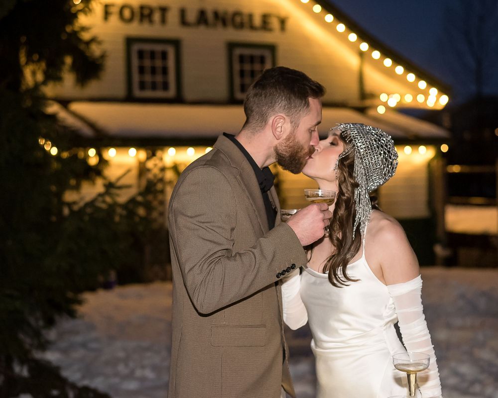 A photo using direct flash to illuminate the bride and groom as they kiss outside in Fort Langley, BC.