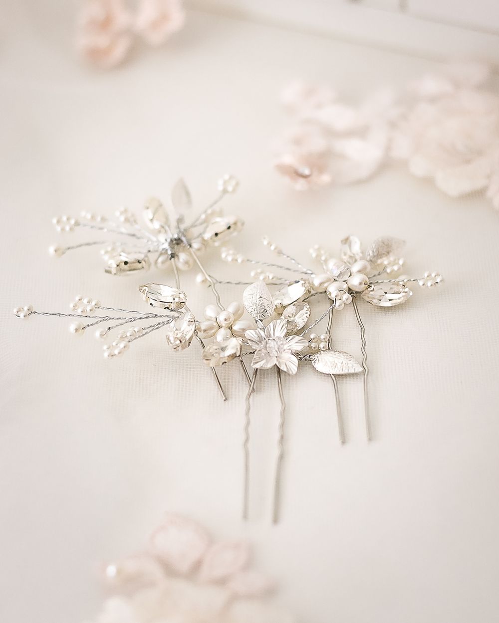 A close up detail image of a bride's silver floral hair pins ready to wear for her wedding day.