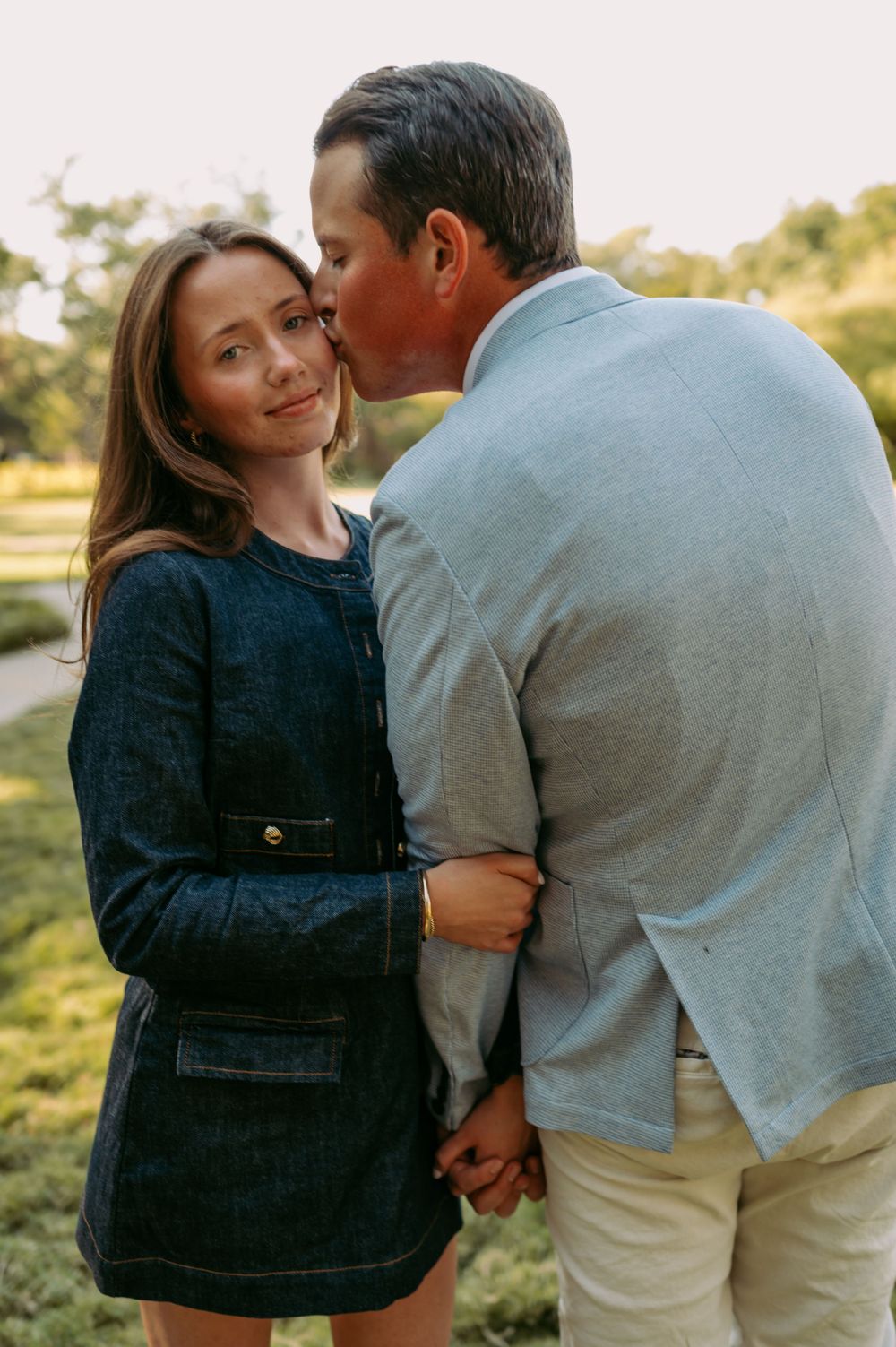 Sweet intimate moment shared between a couple in a park during golden hour.