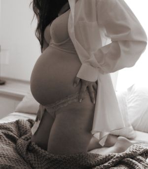 Artistic black and white maternity boudoir photo showing pregnancy silhouette.