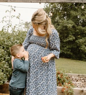 Sweet moment in a garden between mother and child next to raised planter beds.