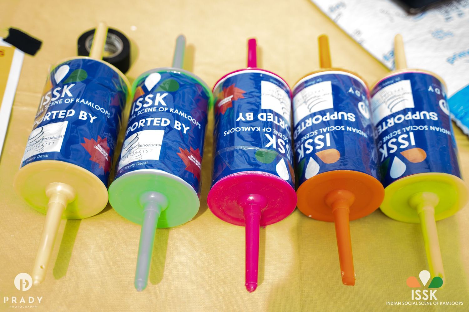 Row of colorful thread spools lined up on a beige surface.
