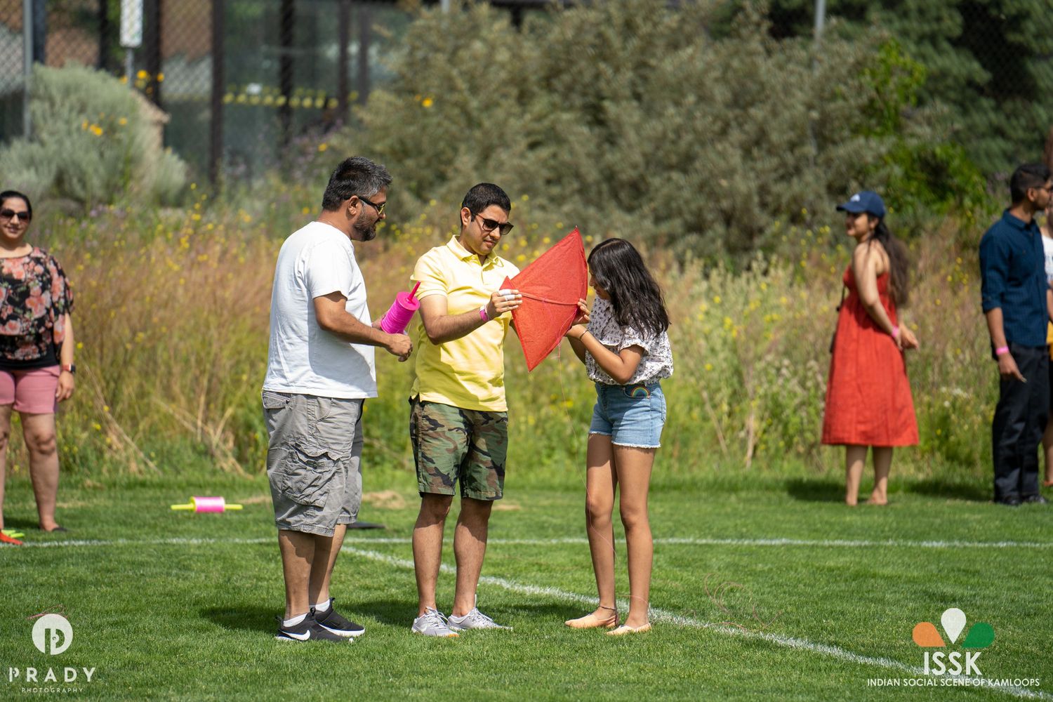 People playing outdoor games on a sunny day in a grassy field.
