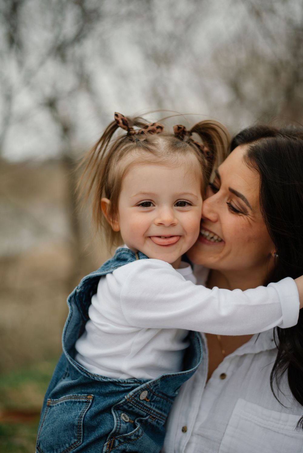 Sweet candid moments between parent and child wearing denim and white outdoors.