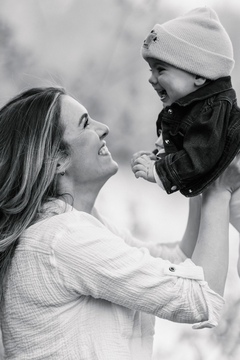 Black and white series capturing tender moments between parent and child wearing winter hats.