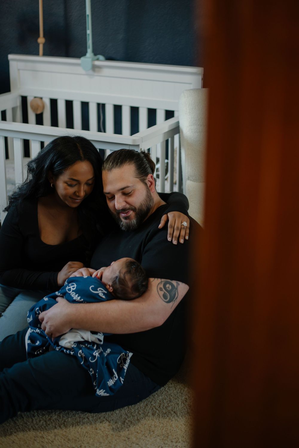 Intimate family moment captured on carpet showing cuddles and laughter indoors.