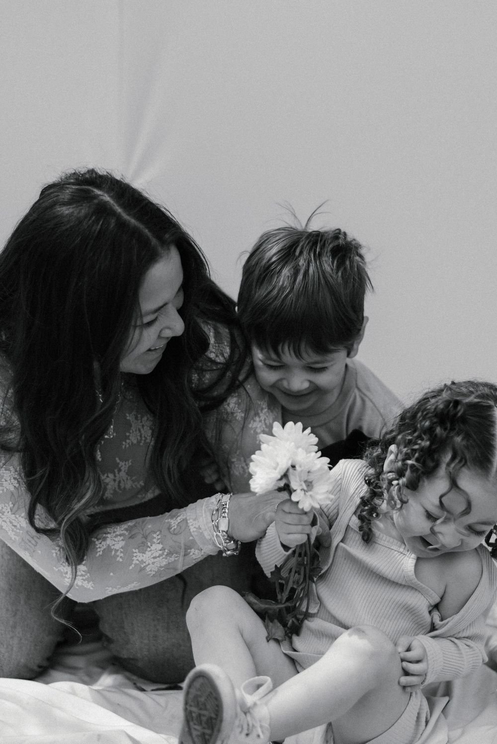 Black and white intimate family portraits with flowers creating tender moments.