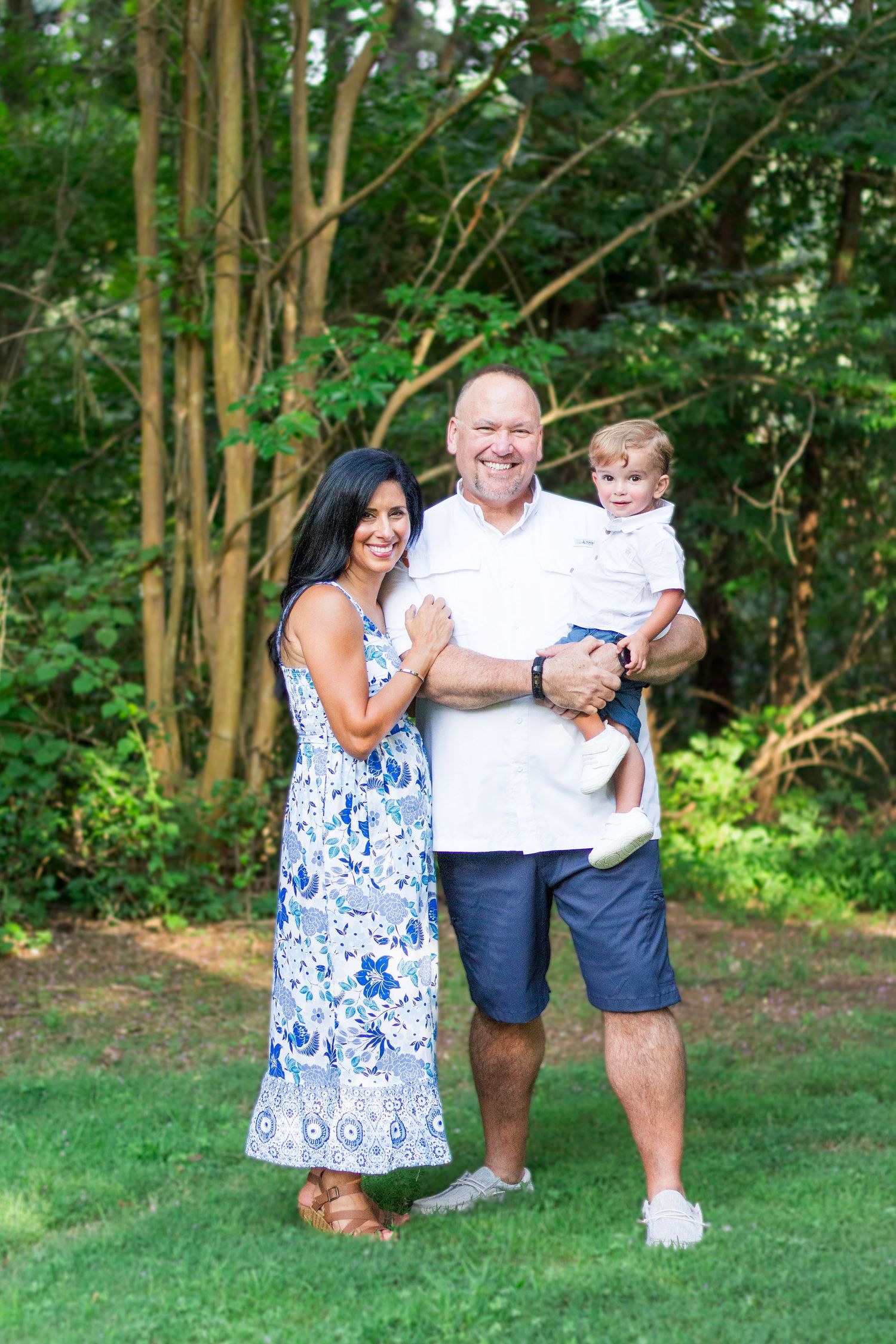 Husband, wife, and son smiling at the camera