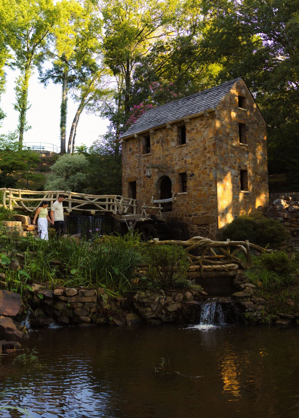 Romantic engagement moment as the couple walks to the proposal location at the Old Mill in Little Rock, AR