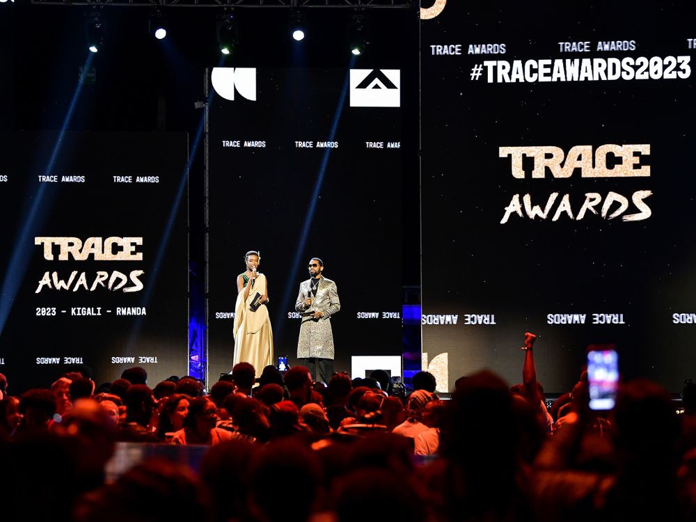 Wide shot of Trace Awards stage with presenters and illuminated branding.