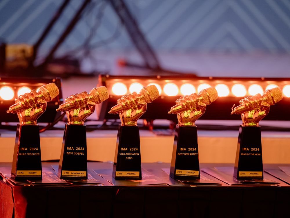Row of golden microphone trophy awards lined up on display at the IMA Awards.