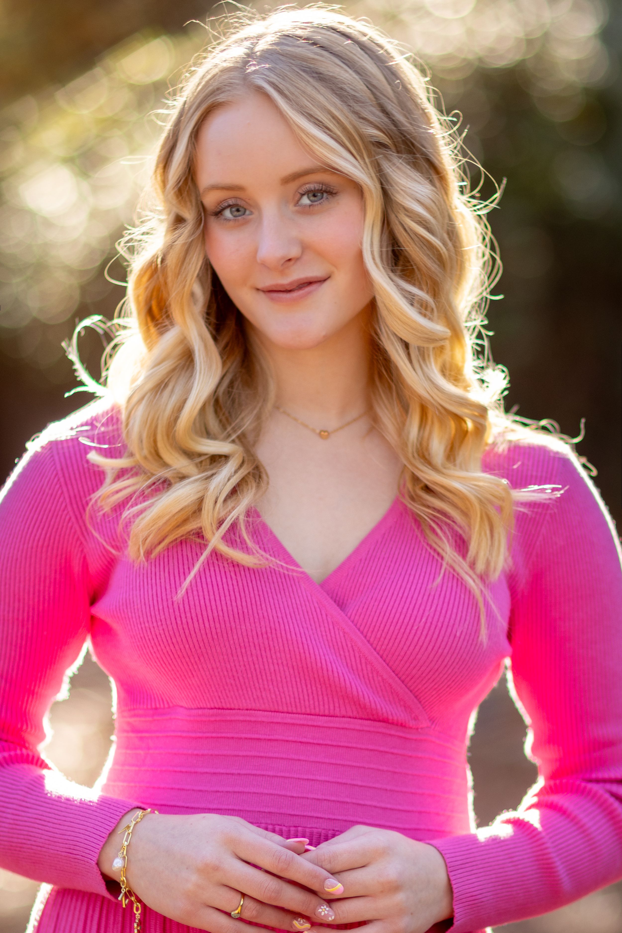 A series of outdoor portraits showing someone in a vibrant pink sweater with backlit golden sunlight creating a warm glow.